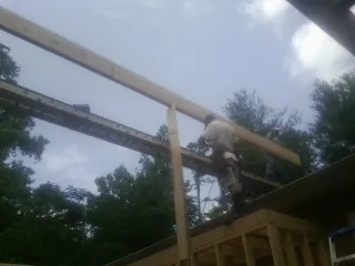 Carpenter setting a ridge beam over a new addition frame — Ice Dam Removal by Roofing Brothers in Strongstown