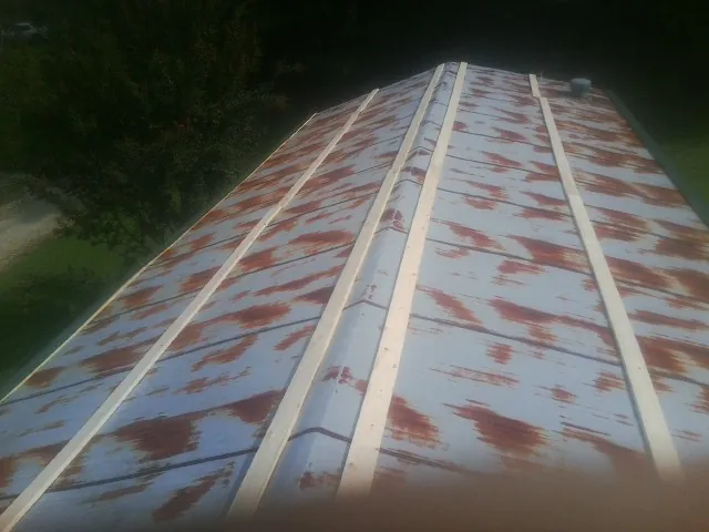 Rusted metal roof panels with new wood purlins before replacement — Storm Damage Roof Repair in Strongstown by Roofing Brothers