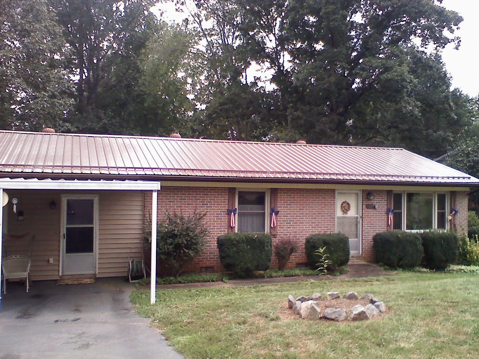 Bronze metal roof and carport on a brick ranch home — Roof Repair work by our crew in Strongstown